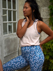 Stehende Frau im Freien trägt den COLIBRI-Leggings mit frischem Margeriten-Motiv – bequem und stylisch für den Alltag.