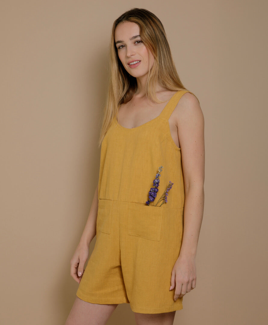 Detailansicht des Leinen-Jumpsuits in Senfgelb, weicher Stoff, femininer Look mit offenem Rückenausschnitt, hergestellt in Frankreich.
