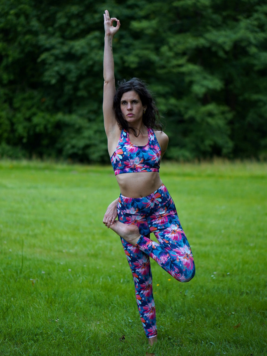 Yoga-Übung im Freien mit dem nachhaltigen Sport-Set aus Bustier und Legging im Lotusblüten-Design.