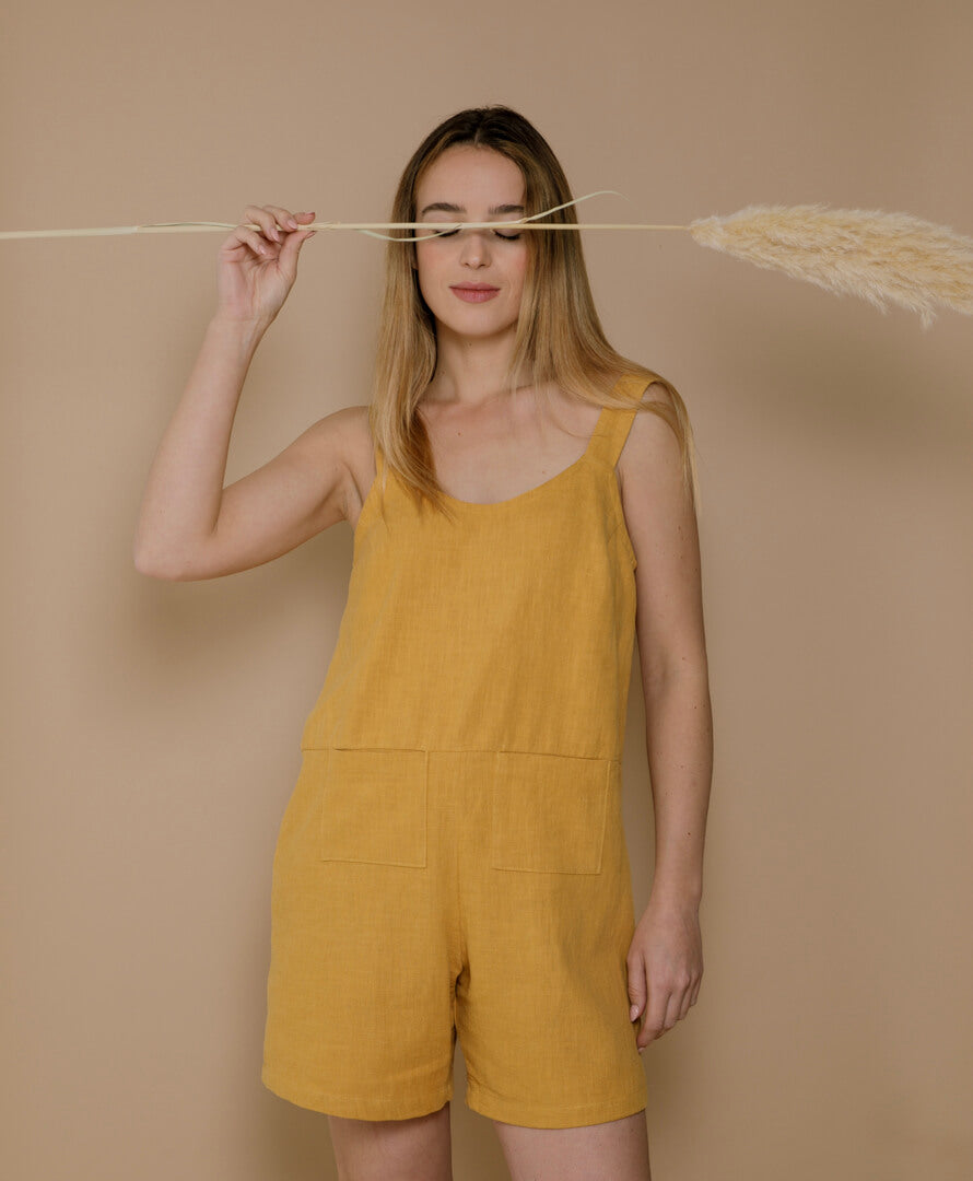 Frau trägt senfgelben Jumpsuit aus 100 % Leinen, nachhaltige Sommermode für Damen, luftiger Look, in Frankreich gefertigt.