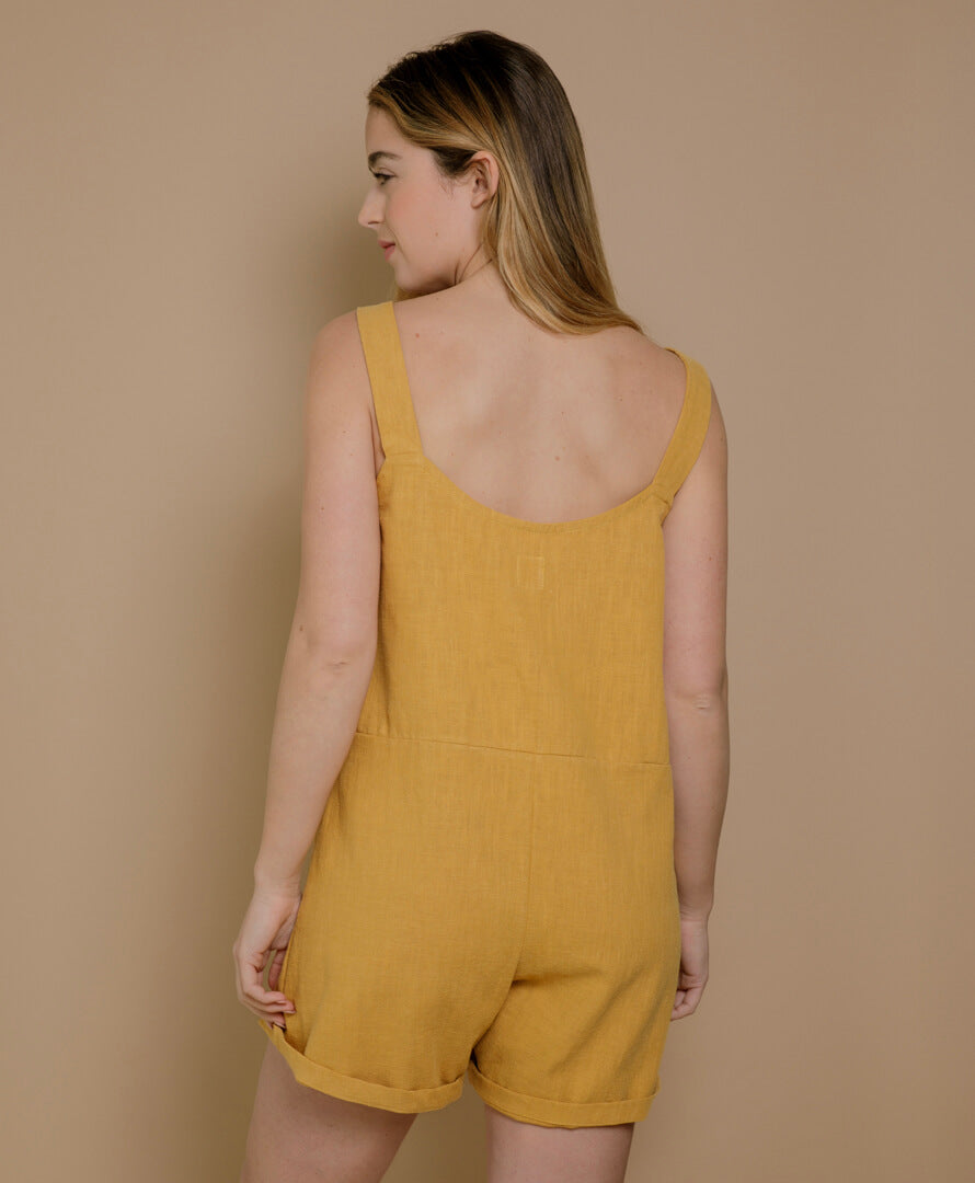 Frau von hinten im Leinen-Jumpsuit in Senfgelb, Rückenausschnitt mit eleganter Note, Sommermode nachhaltig und made in France.