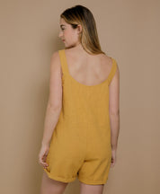 Frau von hinten im Leinen-Jumpsuit in Senfgelb, Rückenausschnitt mit eleganter Note, Sommermode nachhaltig und made in France.