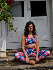 Frau sitzt im Freien in Meditationshaltung, trägt das MÉSANGE Sport-Bustier mit Lotusblüten-Motiv und die passende COLIBRI-Leggings, zeigt Ruhe, Balance und harmonischen Stil.