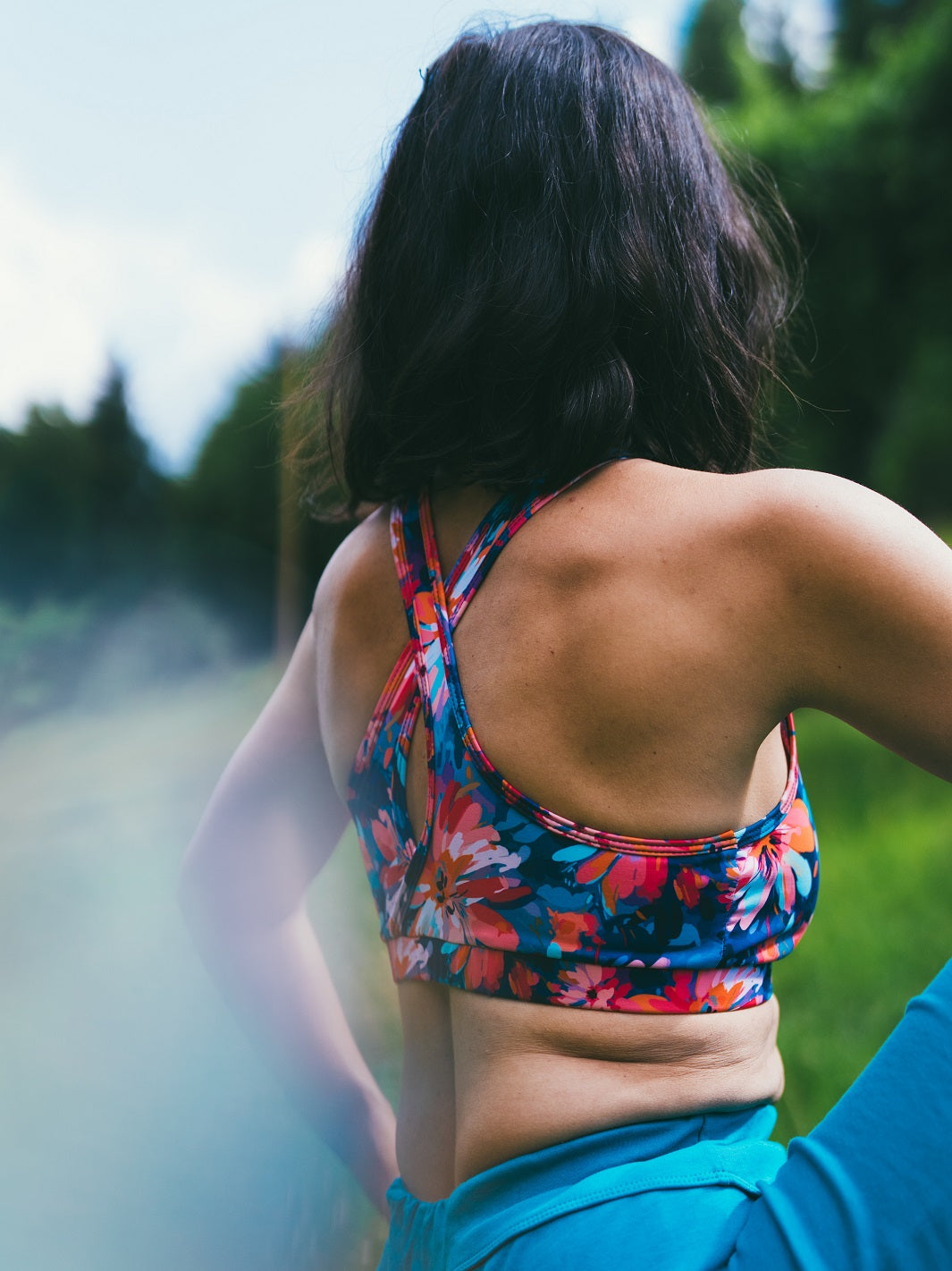 Seitliche Ansicht des MÉSANGE Sport-Bustiers mit Lotusblüten-Motiv im Freien, zeigt die elegante Passform und den femininen Schnitt für harmonische Bewegungen beim Sport.