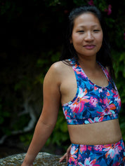 Frau trägt das MÉSANGE Sport-Bustier mit Lotusblüten-Motiv im Freien, zeigt die elegante Passform und den optimalen Halt für Yoga und Pilates.