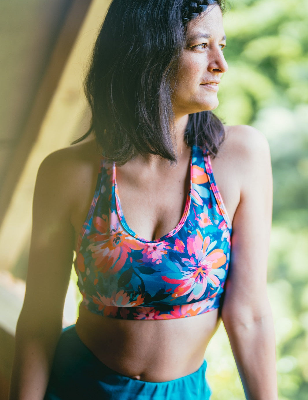 Frau trägt das MÉSANGE Sport-Bustier mit Lotusblüten-Motiv im Freien, vorne sichtbar, ideale Kombination aus Stil, Komfort und optimalem Halt für Yoga und Pilates.