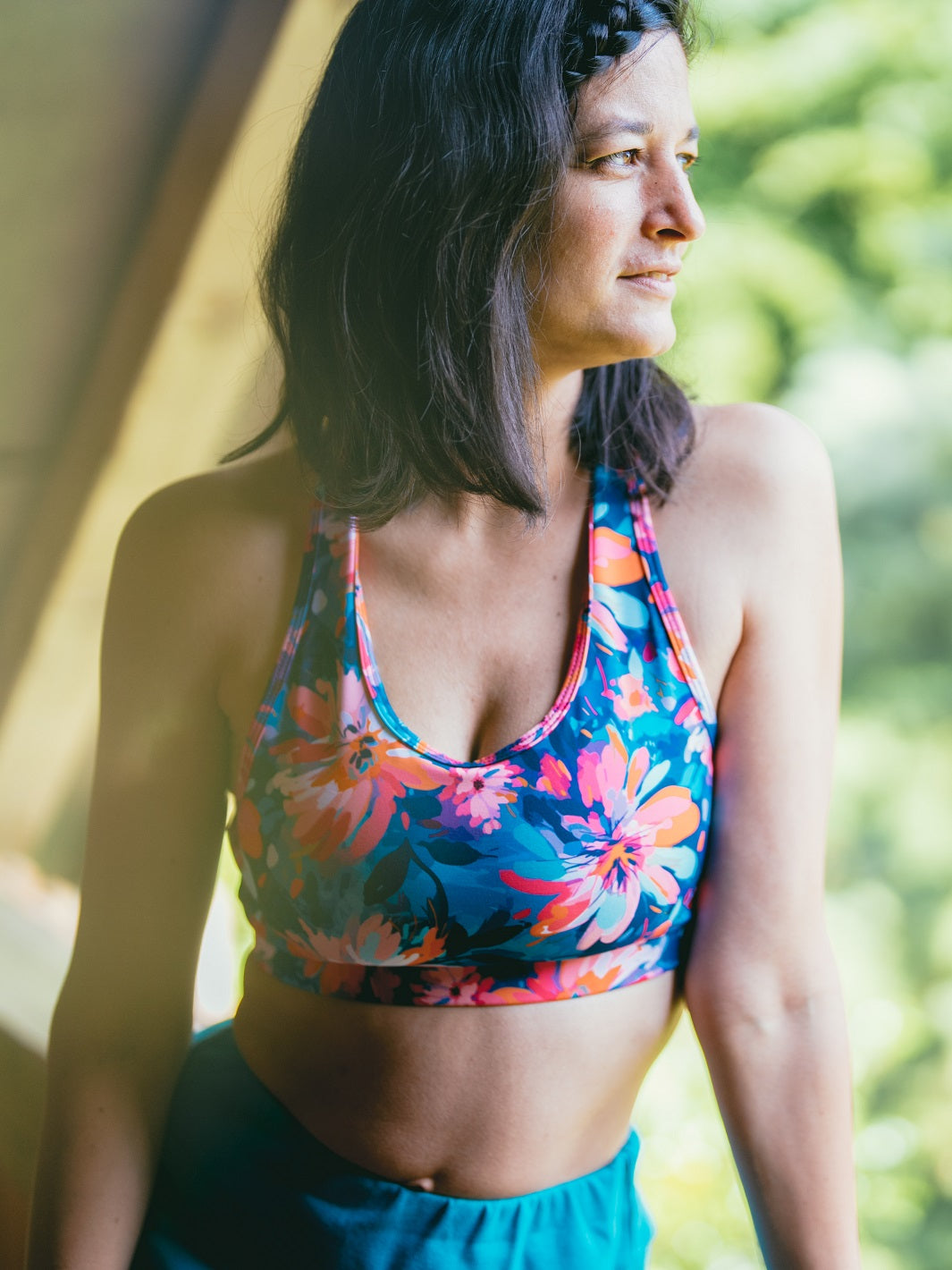 Frau trägt das MÉSANGE Sport-Bustier mit Lotusblüten-Motiv im Freien, vorne sichtbar, ideale Kombination aus Stil, Komfort und optimalem Halt für Yoga und Pilates.