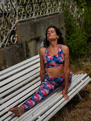Frau trägt das MÉSANGE Sport-Bustier mit Lotusblüten-Motiv und die passende COLIBRI-Leggings beim Yoga im Freien, seitliche Ansicht, zeigt elegante Haltung und optimalen Halt.