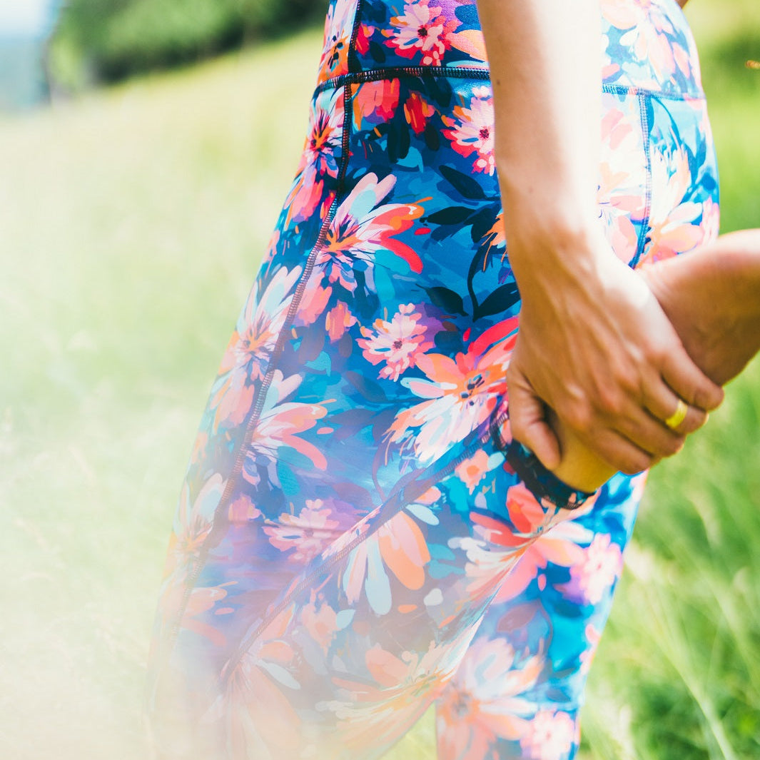 Detailaufnahme des Sport-Leggings mit Lotusblüten-Motiv, getragen im Freien.