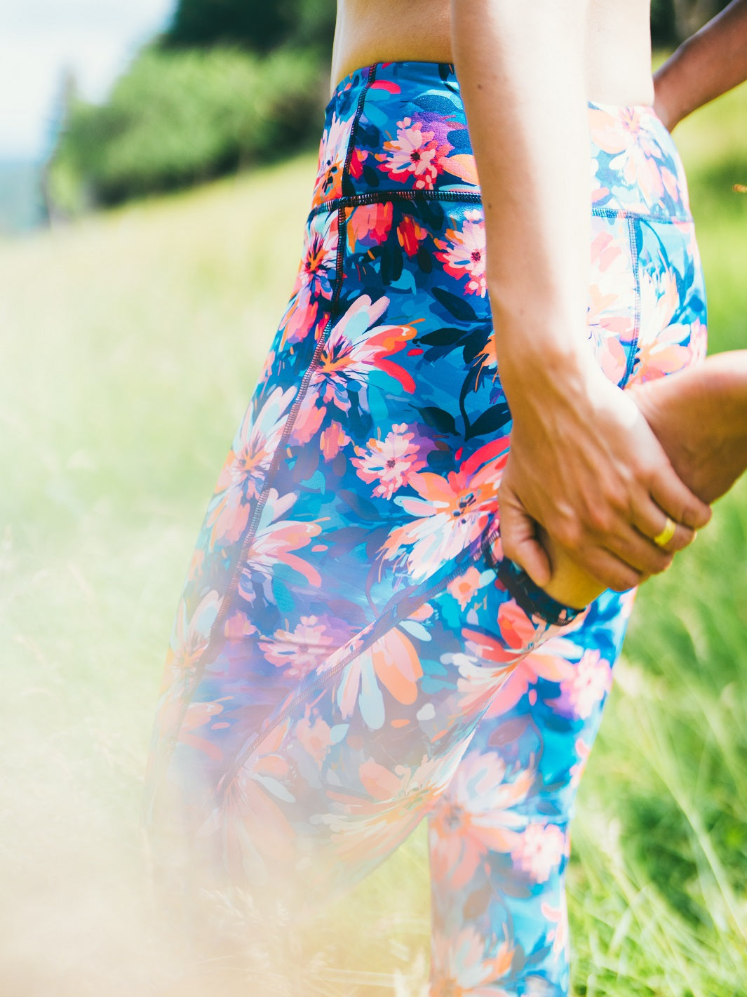 Detailaufnahme des Sport-Leggings mit Lotusblüten-Motiv, getragen im Freien.