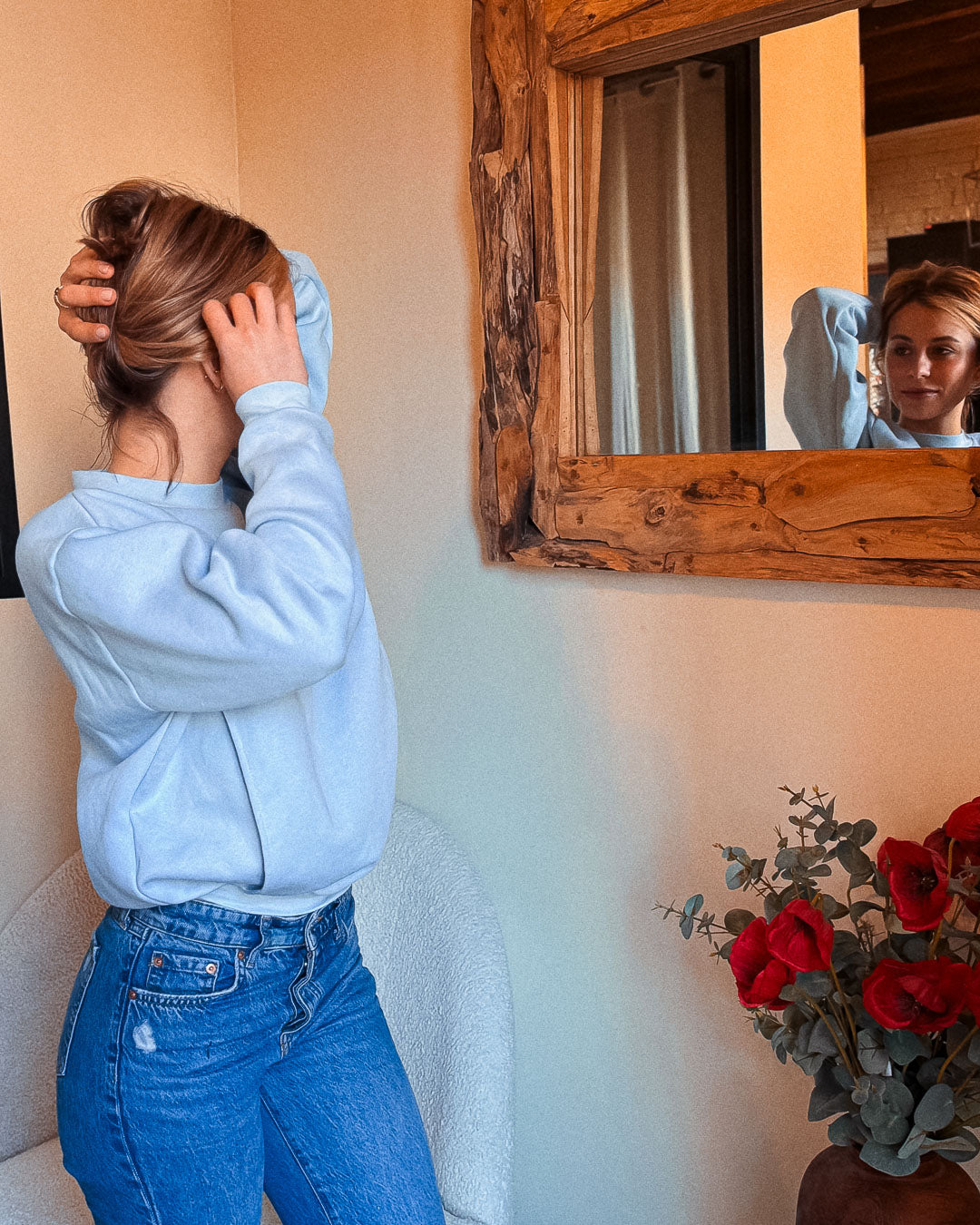 Frau steht und trägt den Stillpullover Mimosa in Babyblau – moderner Oversize-Schnitt, ohne Reißverschluss.