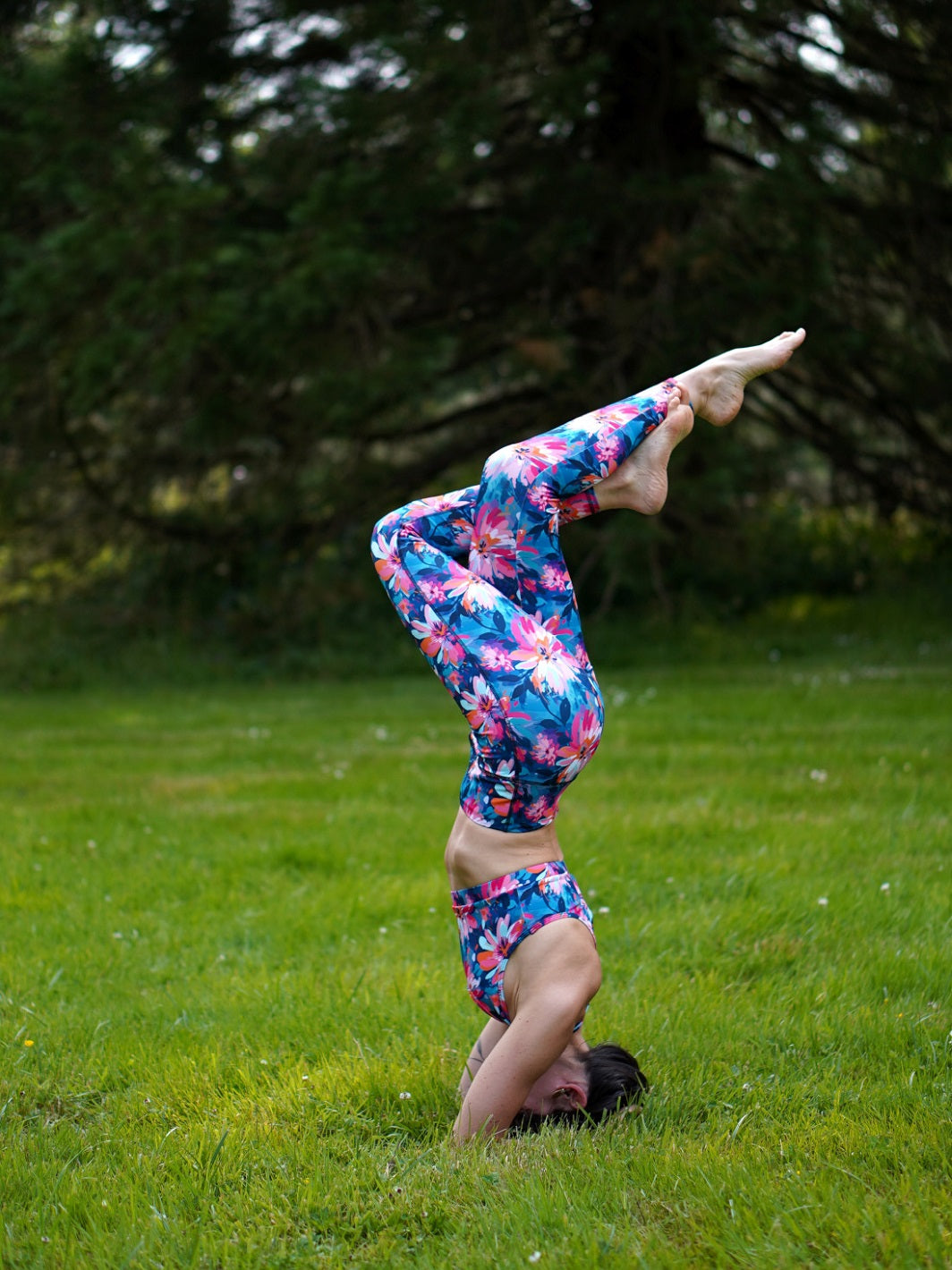 Komplettes Yoga-Outfit mit Bustier und Legging im Lotusblüten-Motiv, getragen bei einer Asana im Freien.