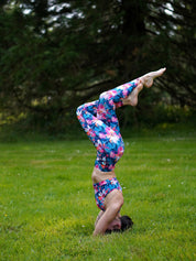 Komplettes Yoga-Outfit mit Bustier und Legging im Lotusblüten-Motiv, getragen bei einer Asana im Freien.